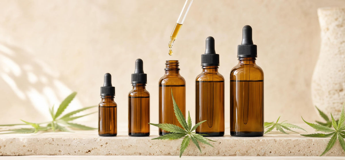 Frascos de óleo de CBD de diferentes concentrações com conta-gotas e folhas de cânhamo